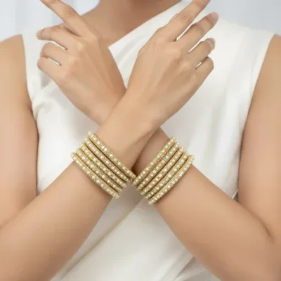 Beautiful gold bangles adorned with pearls and zircon stones, perfect for traditional and festive occasions.